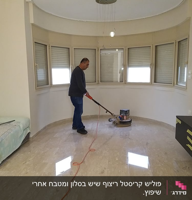 אדם מנקה רצפה עם מכונת פוליש בחדר ריק
